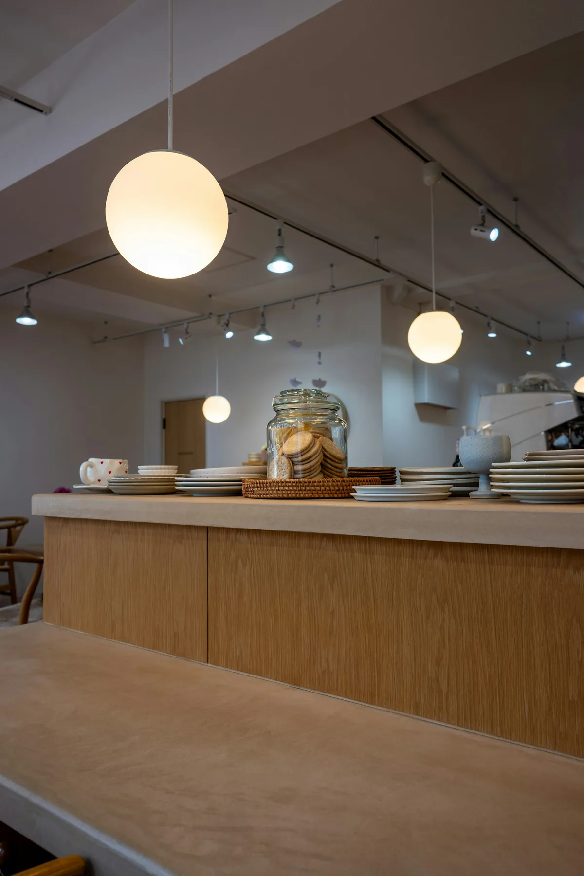 Warm café counter with plates, cookies, and globe lights